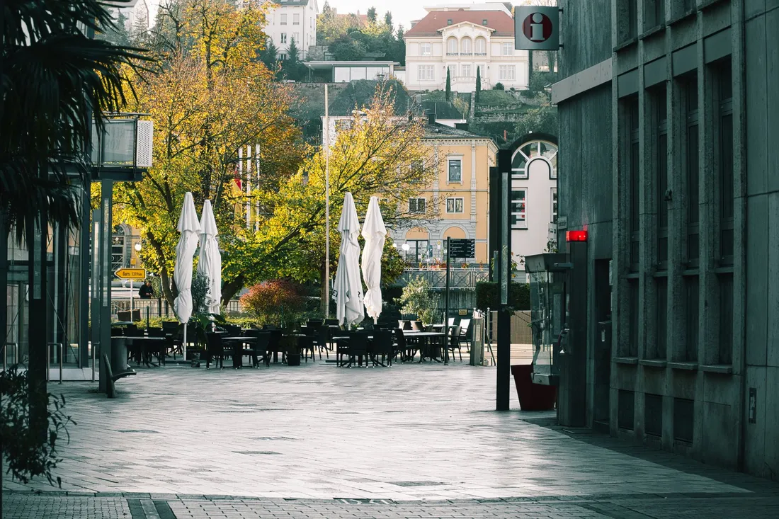 Belebter Stadtplatz mit Cafés und Altbaufassaden